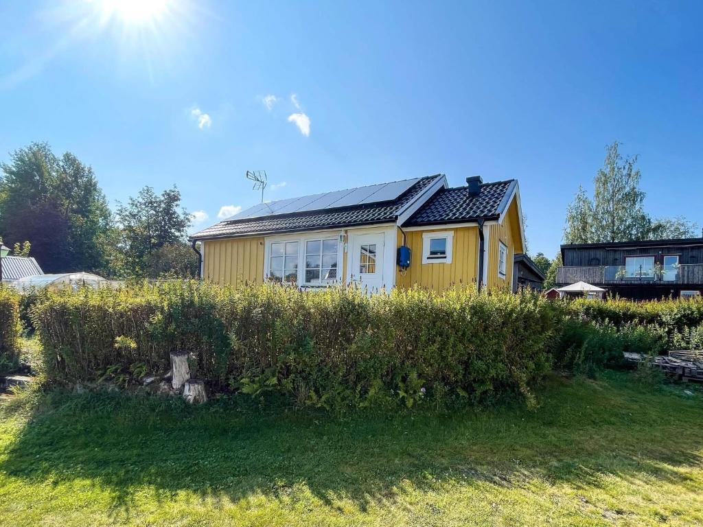 a yellow house with a solar roof on a field at 4 star holiday home in Vingåker in Julita