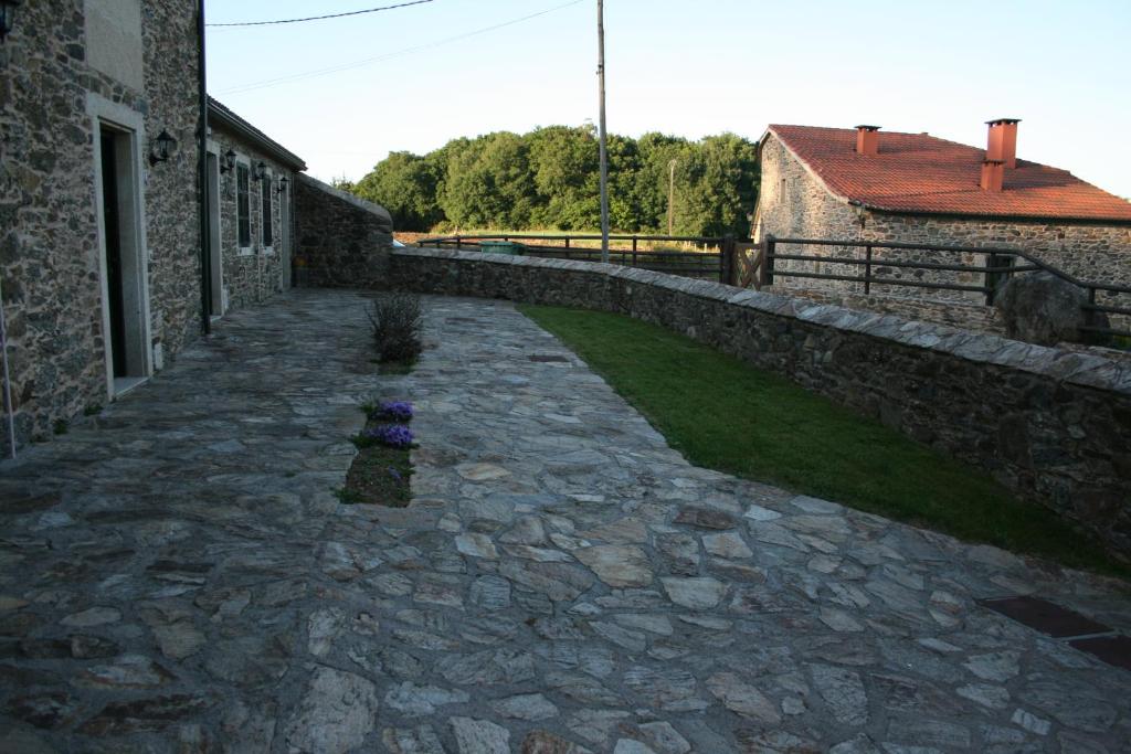 a stone walkway next to a building with a yard at Casa Teillor in Moldes