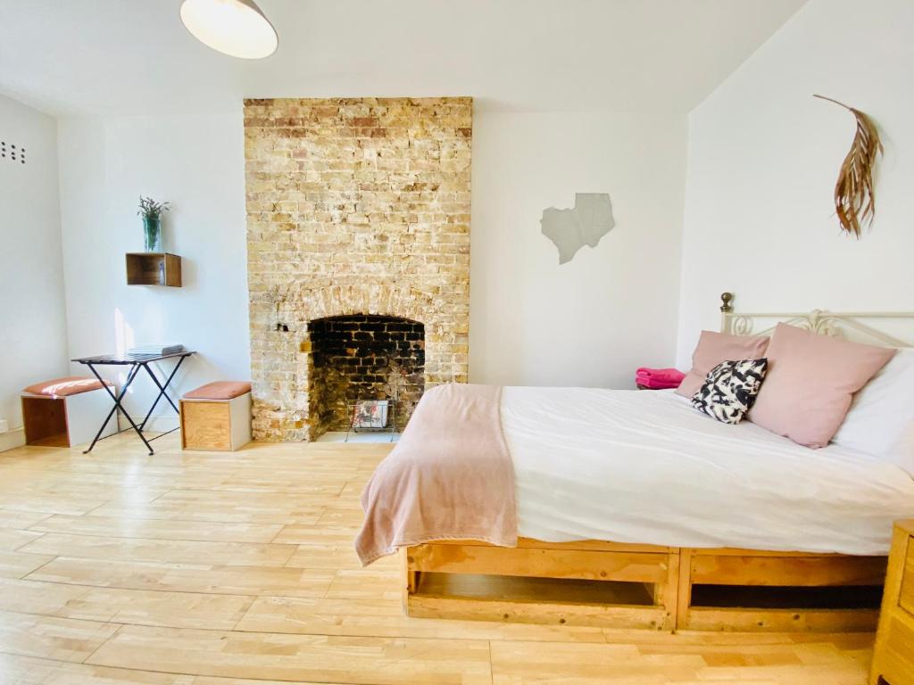 Un dormitorio con una cama y una pared de ladrillo. en London's Central East End 2 Bedroom City Apartments, en Londres