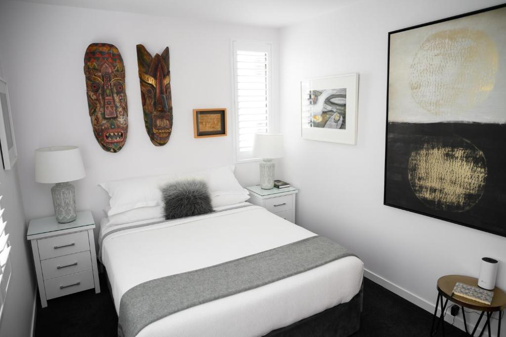 奥克兰Omahanui - City fringe guesthouse的卧室配有一张床,墙上设有两个冲浪板