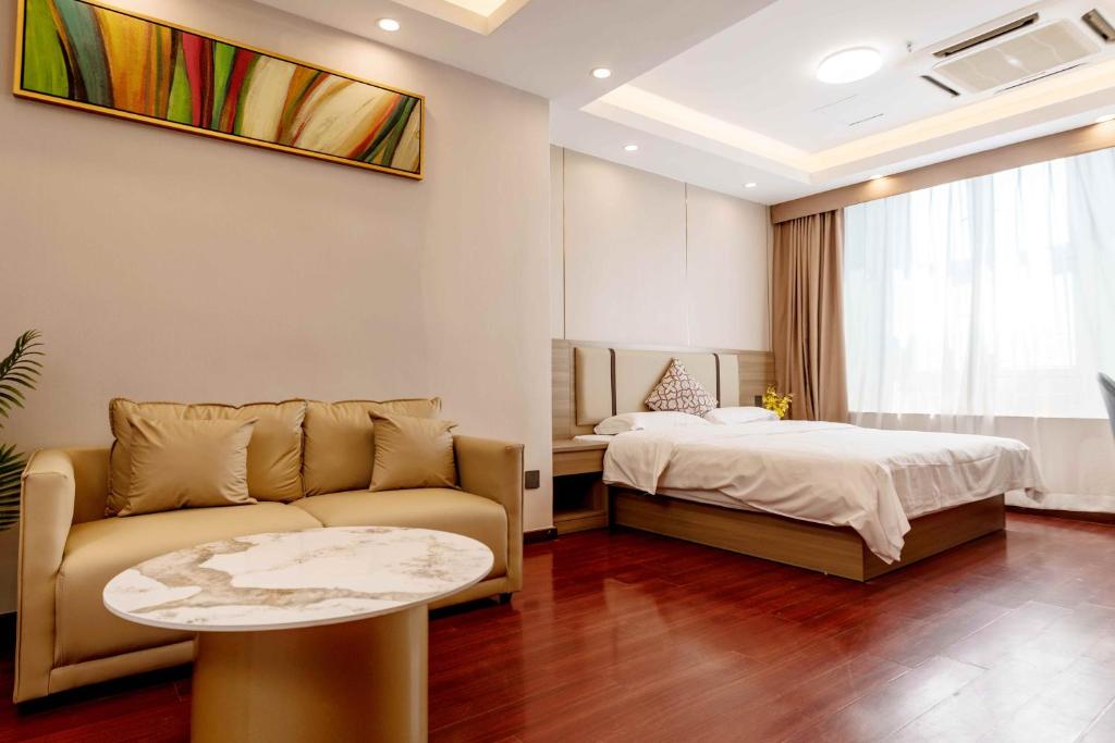 a living room with a couch and a bed at Guangzhou Xingke Apartment in Guangzhou