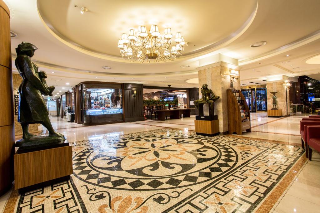 a lobby with a statue of a man on the floor at Pacific Hotel in Seoul