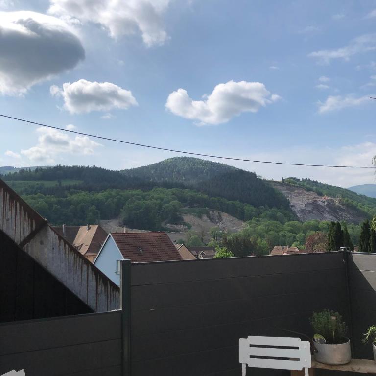 un banc blanc sur un balcon avec vue sur une montagne dans l'établissement Le duplex de l ancienne forge, à Muhlbach-sur-Munster