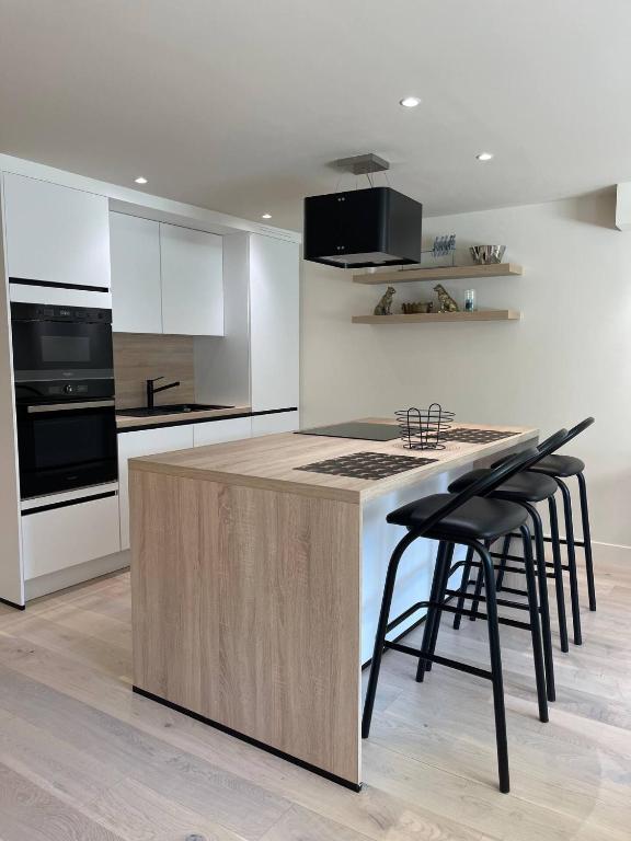 a kitchen with a island with bar stools at Modern Flat With Garden in Ostend