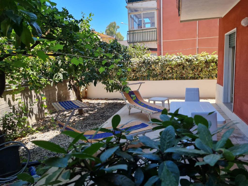 a patio with two chairs and a table and a fence at Elisabeth House in Giardini Naxos