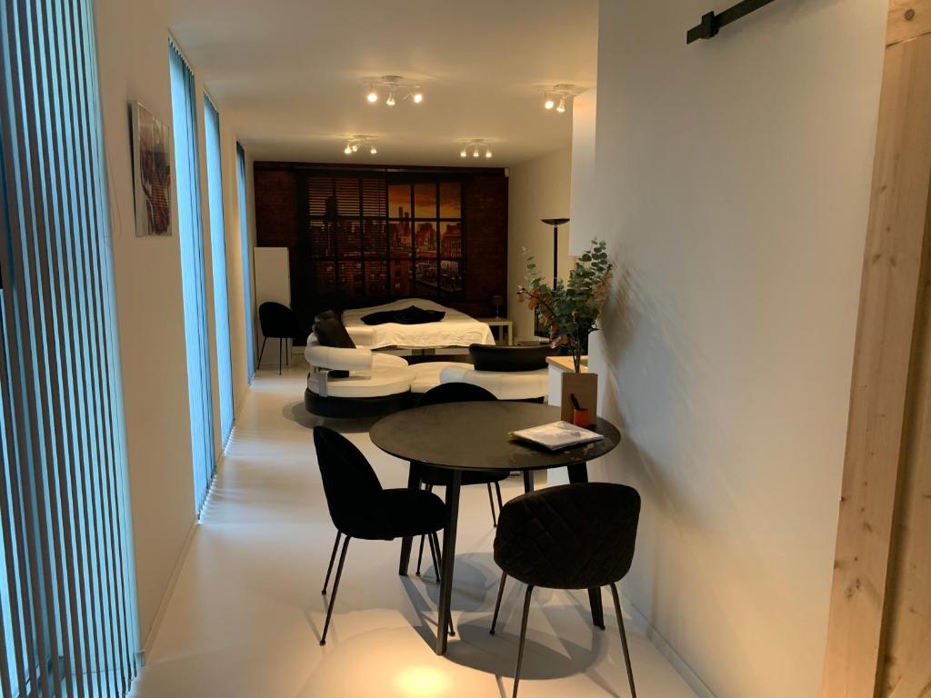 una camera con tavolo, sedie e letto di Prachtige gastsuite in Ranst "Studio 34" a Ranst