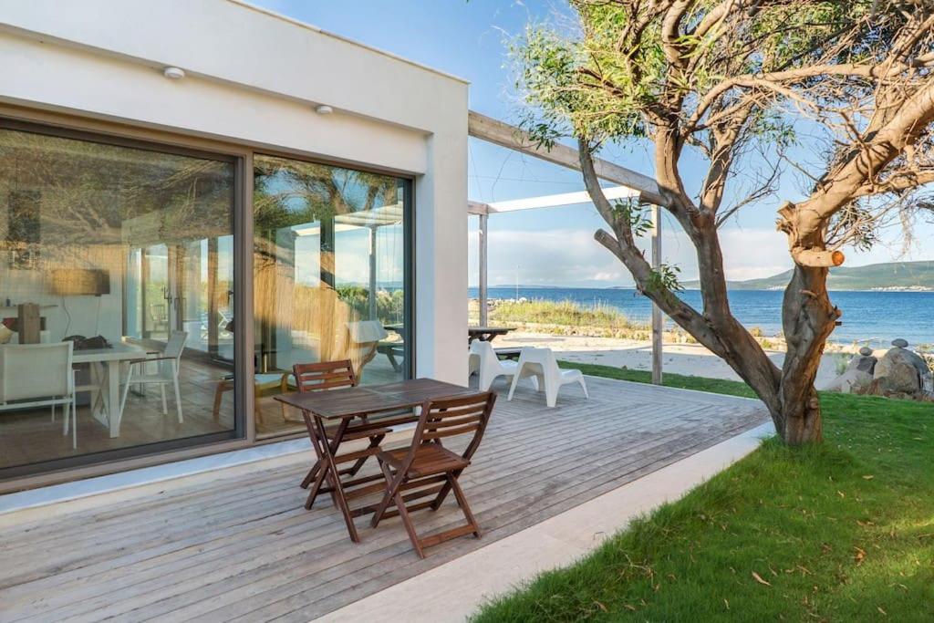 Una terraza de madera con una mesa y sillas. en Urla Seaside House, en Ildir