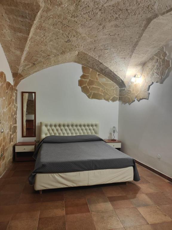 a bedroom with a bed and a stone wall at Casa Vacanza De Flagilla in Brindisi