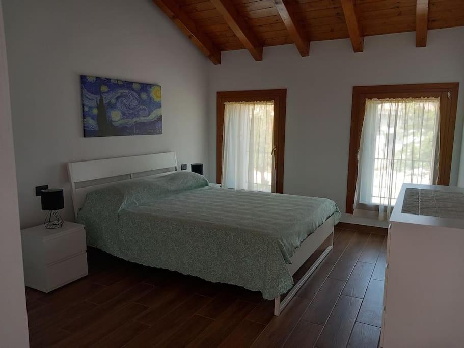 Un dormitorio con una cama y dos ventanas. en Tra antico e moderno, en Villa Marin