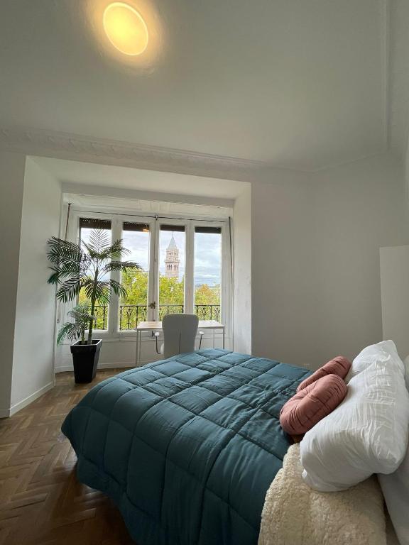 une chambre avec un grand lit et une grande fenêtre dans l'établissement Creativity Quarters Habitación temporada en coliving para estudiantes, trabajadores y artistas, à Madrid