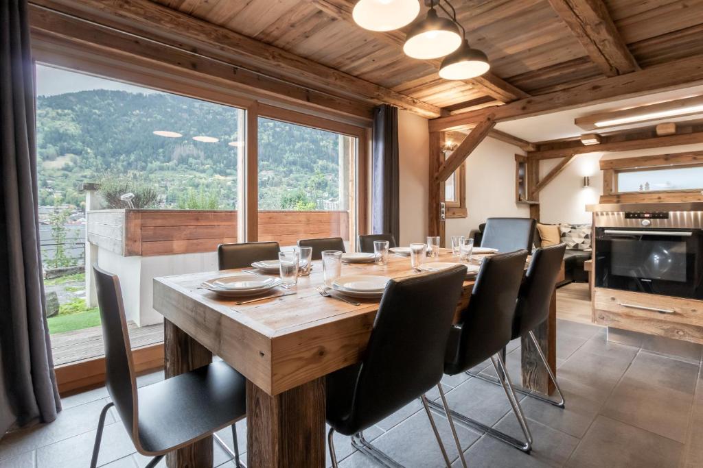 une salle à manger avec une table et des chaises et une grande fenêtre dans l'établissement Le Covagnet, à Saint-Gervais-les-Bains