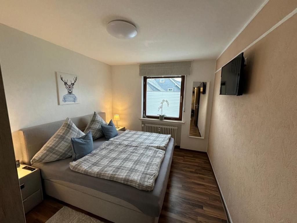 een kleine slaapkamer met een bed en een televisie bij Ferienwohnung Winterberg Centrum 2 mit privatem Ski Keller in Winterberg
