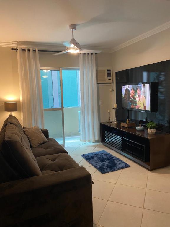 a living room with a couch and a flat screen tv at Apto a 50m da praia in Balneário Camboriú