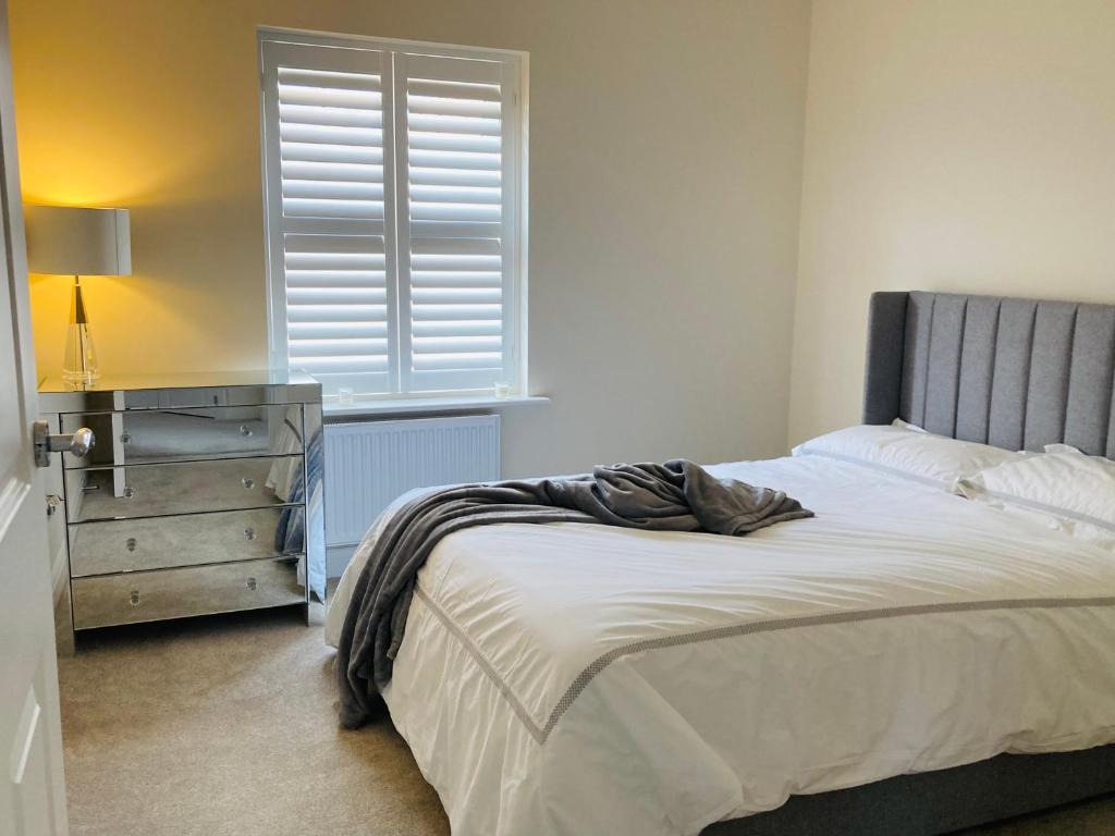 a bedroom with a bed and a dresser and a window at House-Sleeps 8-Parking-Garden in Weekley
