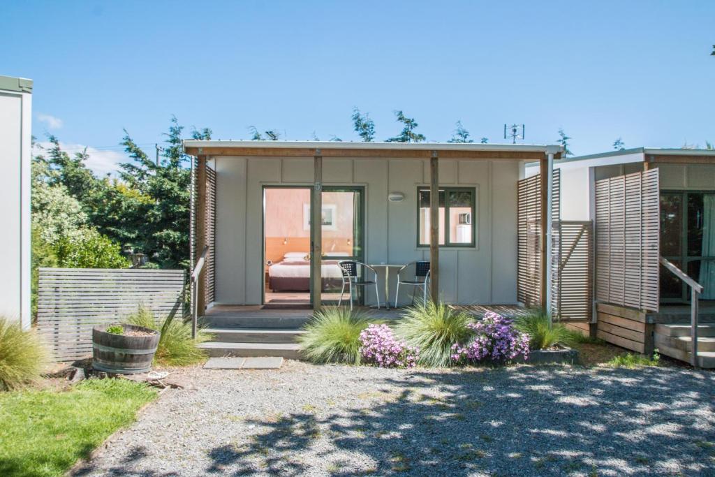 a tiny house with a bedroom in a backyard at Martinborough TOP 10 Holiday Park in Martinborough