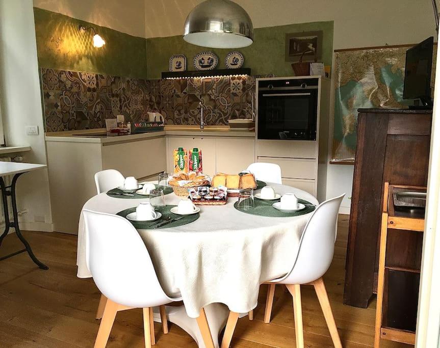 a dining room table with a white tablecloth and chairs at Dodici Lune Apartment in Rovereto