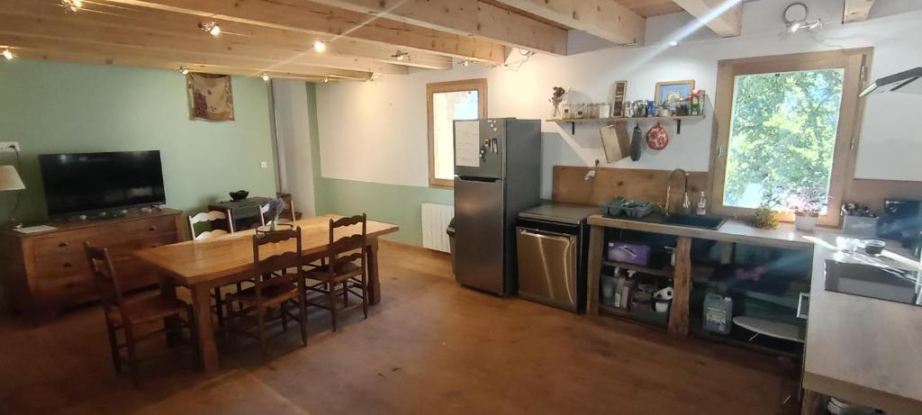 a kitchen with a wooden table and a dining room at JAS provençal pour 6 personnes à 2mn de la Grange de Javon in Monieux