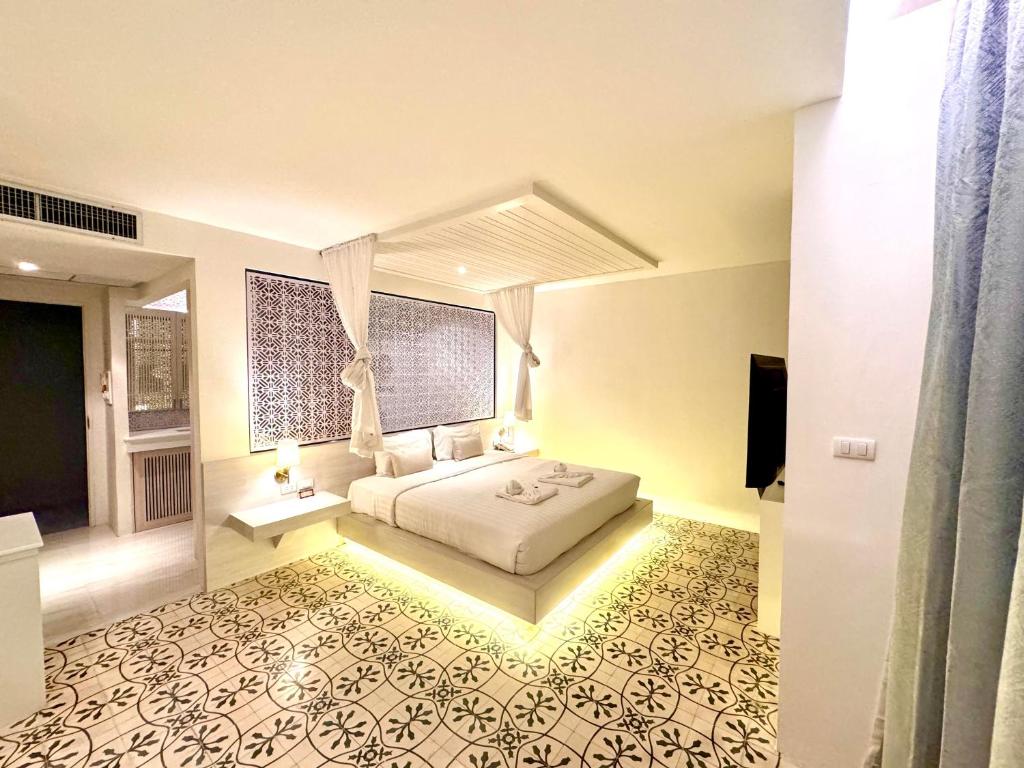 a bedroom with a bed and a tv in a room at De Cozé Hotel in Patong Beach