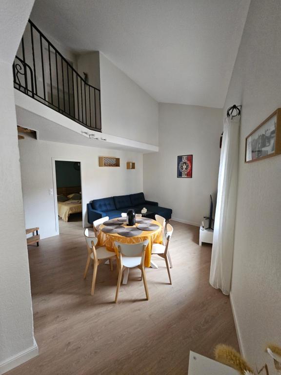 un salon avec une table, des chaises et un canapé dans l'établissement Appartement proche des Halles, à Narbonne