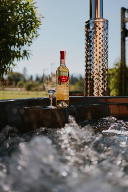 a bottle of wine and a glass sitting on a tub at Tatra House z Jacuzzi in Poronin