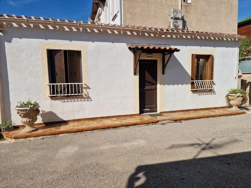 une maison blanche avec deux fenêtres et une porte dans l'établissement Le Tony, à Marseille