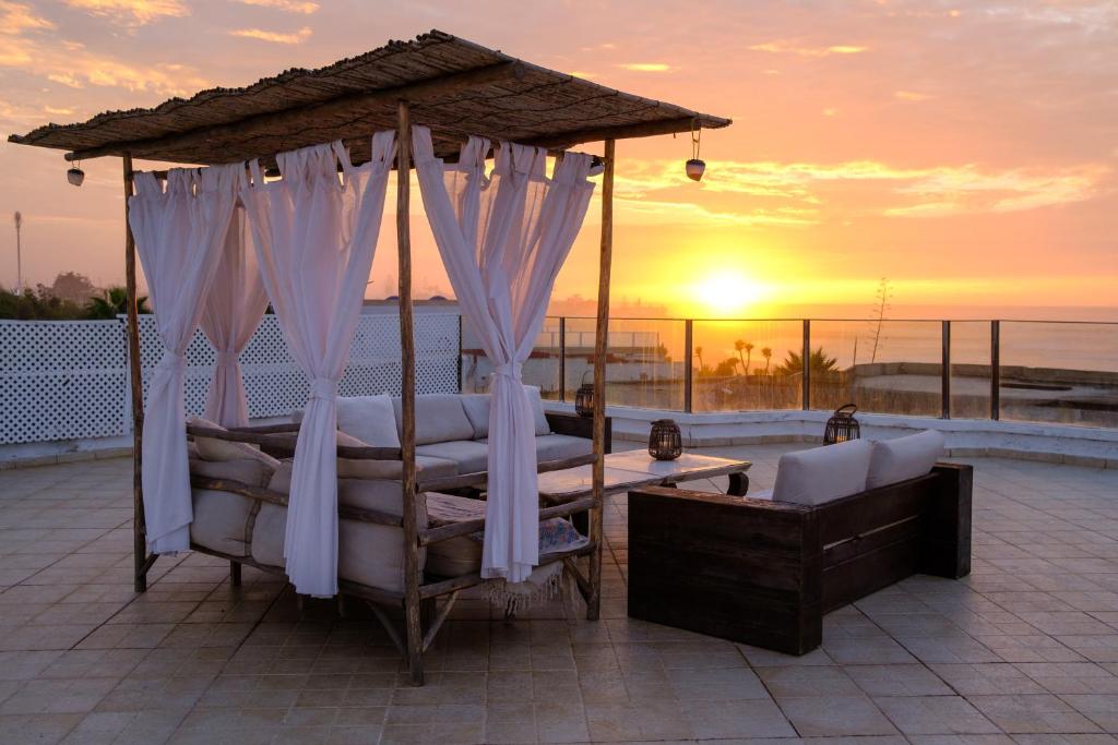 a bedroom with a canopy bed with a sunset in the background at Sunset escape by the sea in Temara