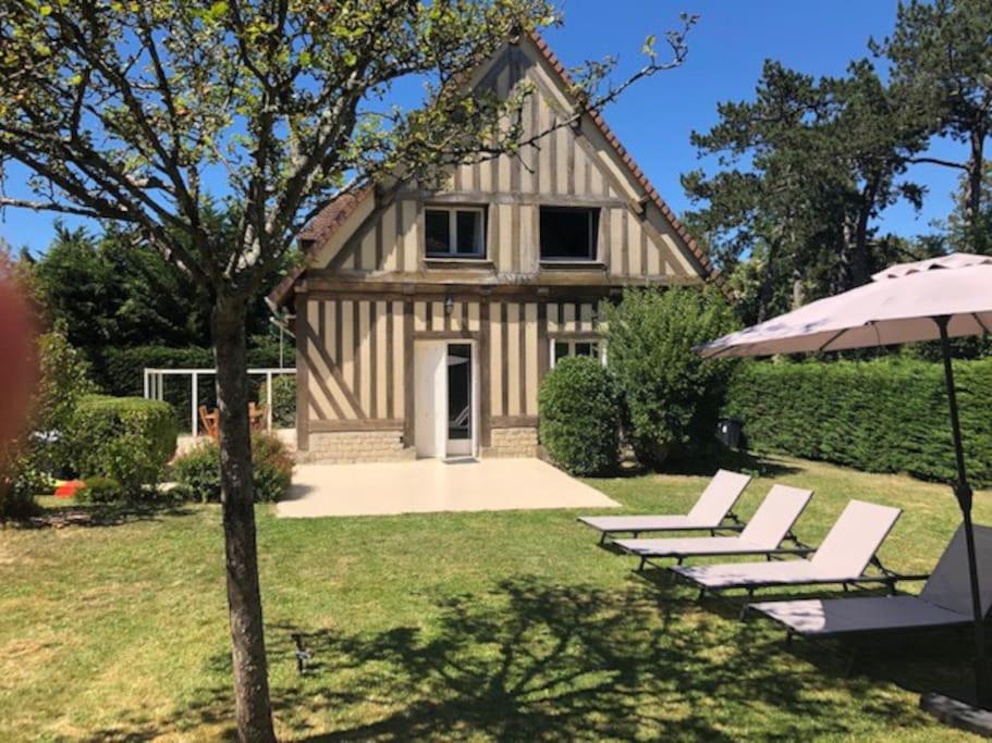 - un groupe de chaises et un parasol devant une maison dans l'établissement Deauv'hills House, à Deauville