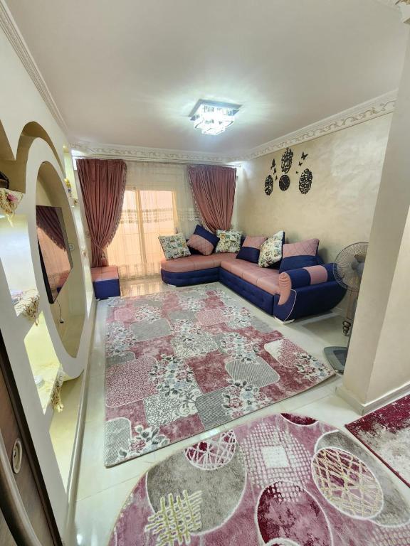 ein Wohnzimmer mit einer Couch und einem Teppich in der Unterkunft Beautiful Old Apartment in Madinat Al Ashir min Ramadan