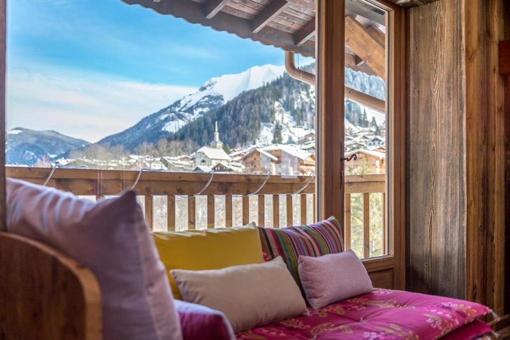 - un canapé dans une pièce dotée d'une grande fenêtre dans l'établissement Montjoie, aux Contamines-Montjoie