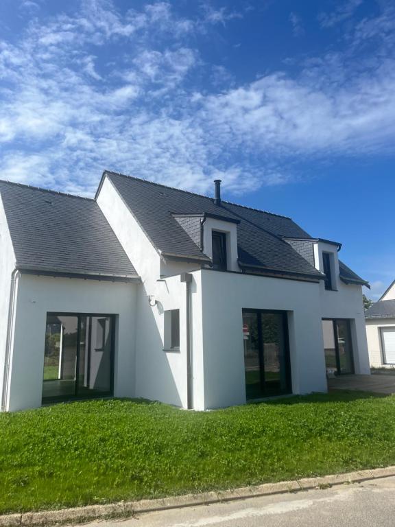 une maison blanche avec un toit noir dans l'établissement Port lenn, à Arzon