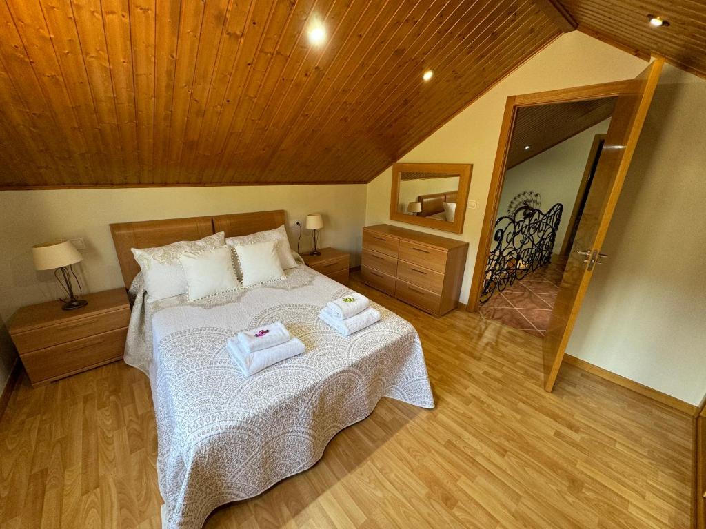 Un dormitorio con una cama con dos toallas encima. en Casa Costeira, en Redondela