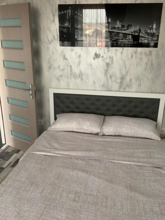 a bedroom with a large bed with a gray headboard at Serin Blaxy Studio in Mangalia