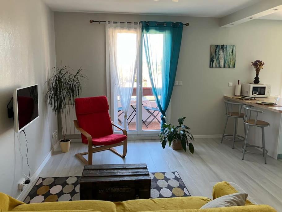 - un salon avec un canapé et un fauteuil rouge dans l'établissement Appartement Barrière de Paris-Ponts jumeaux, à Toulouse