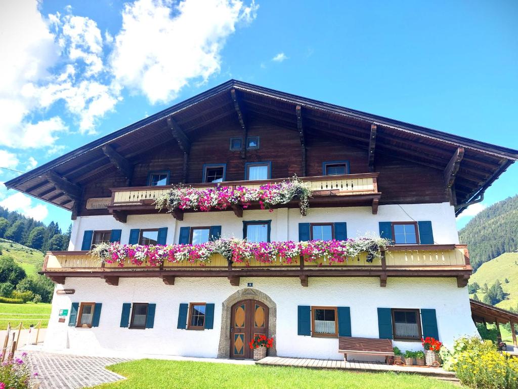 a large house with flowers on the side of it at Ferienwohnungen Foidlhof in Hochfilzen