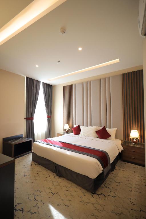 a bedroom with a large bed with red pillows at الريد فال للشقق المخدومة in Jeddah