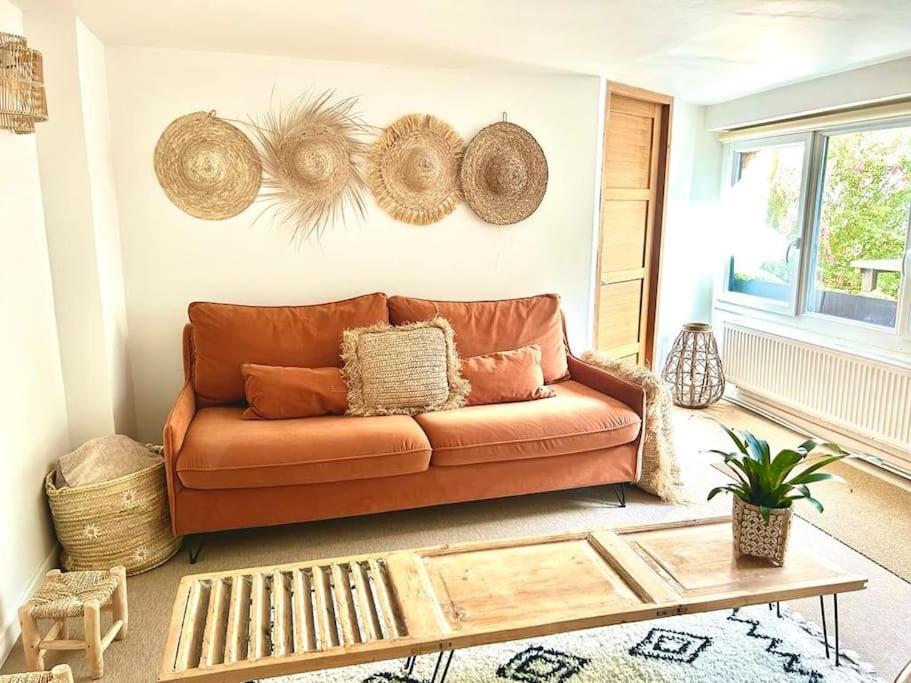 a living room with a leather couch and a coffee table at Logement avec jardin à 200m de la digue in Wimereux