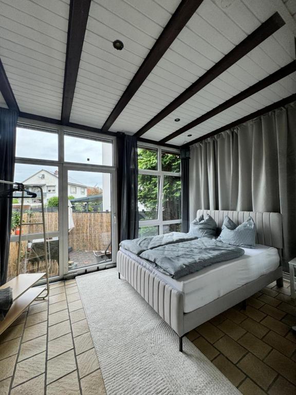 a bedroom with a bed in a room with windows at Cozy Oldhouse Appartment Varenseller in Rheda-Wiedenbrück