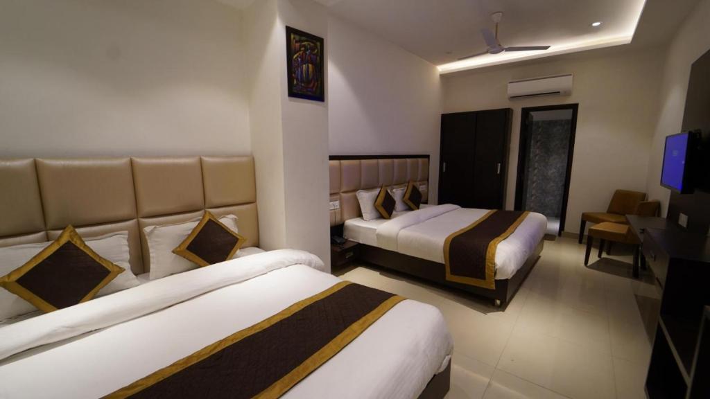 a hotel room with two beds and a television at Hotel Avi inn Near BY Golden Temple in Amritsar