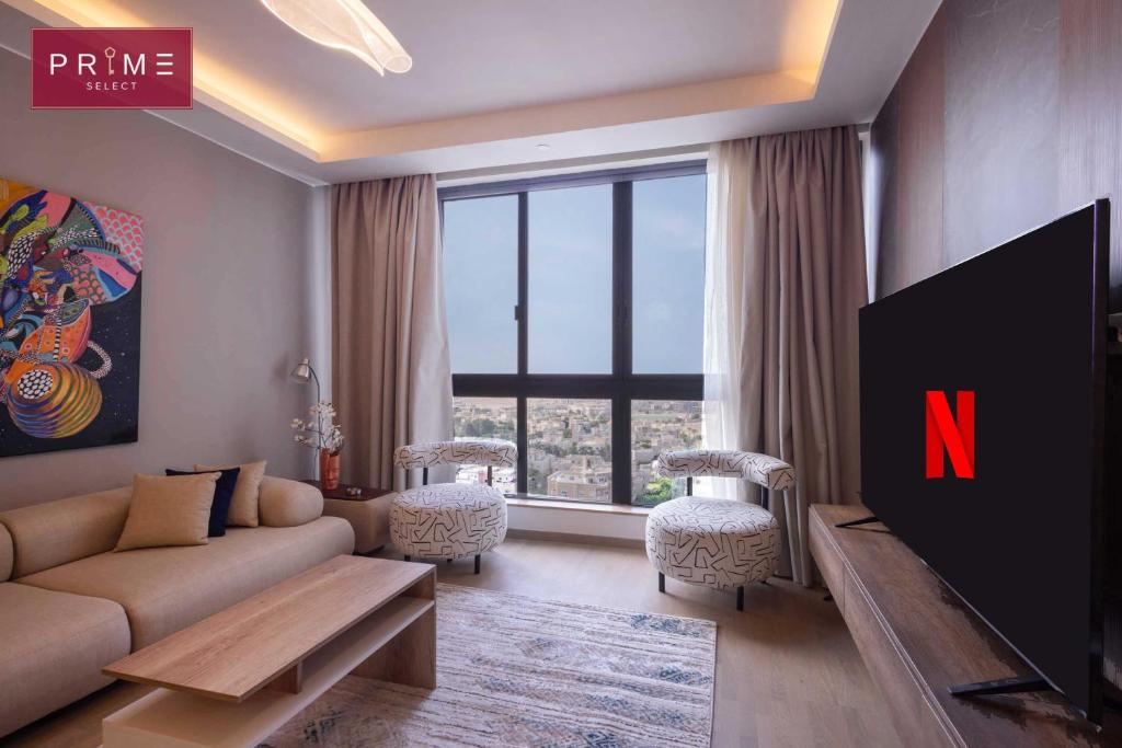 een woonkamer met een bank en een tv bij Prime Select Mall of Arabia in Zes oktober (stad)