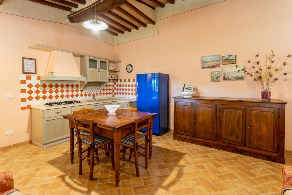 a kitchen with a wooden table and a blue refrigerator at Agriturismo Vergelle in Montalcino