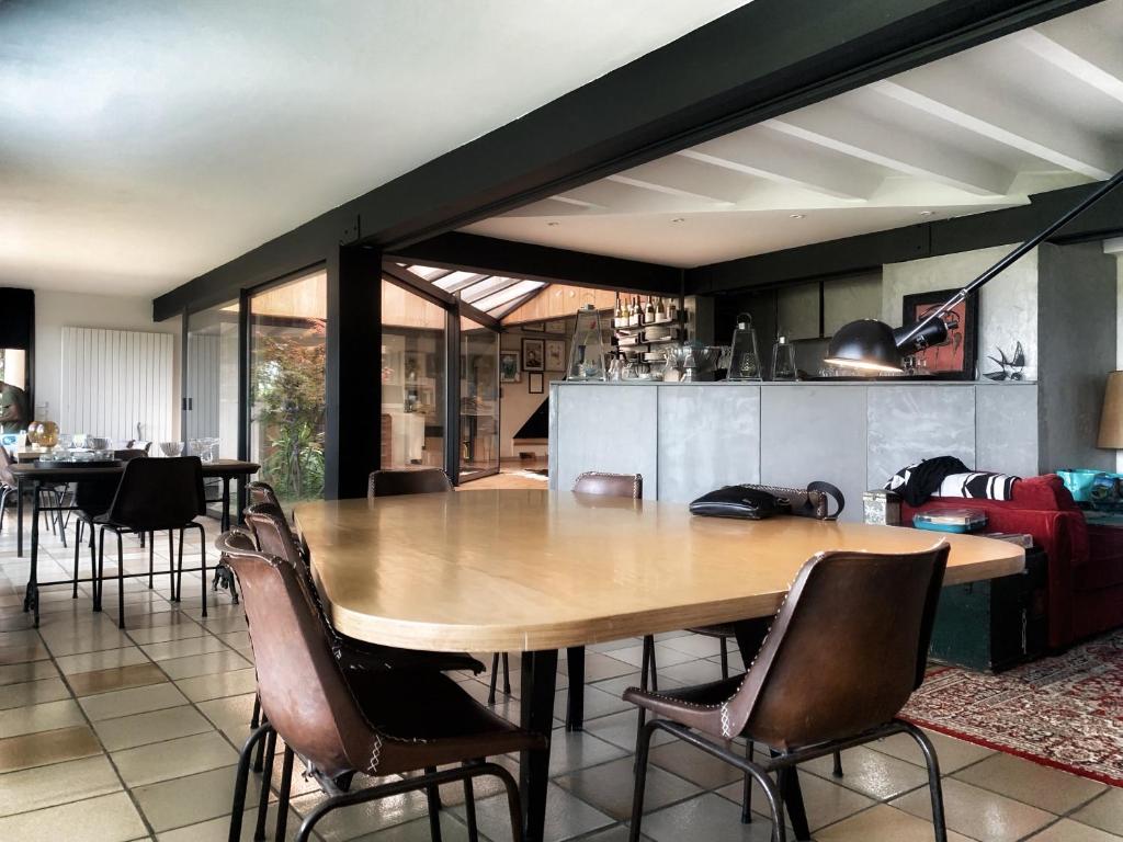 a dining room with a large wooden table and chairs at Casa mARTa : Suites, terrasses et vue panoramique in Tournon-sur-Rhône