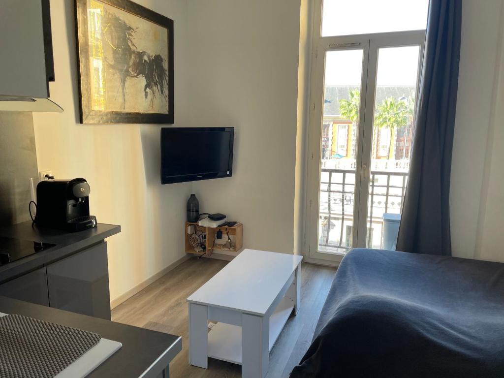 un petit salon avec un lit et une table dans l'établissement Superbe appartement en plein centre ville de Nice!, à Nice