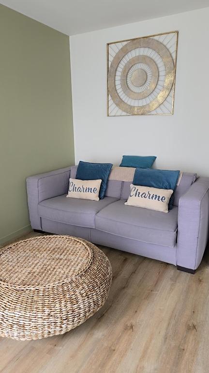 - un canapé violet dans le salon avec un tapis dans l'établissement Landon Cottage, à Campénéac