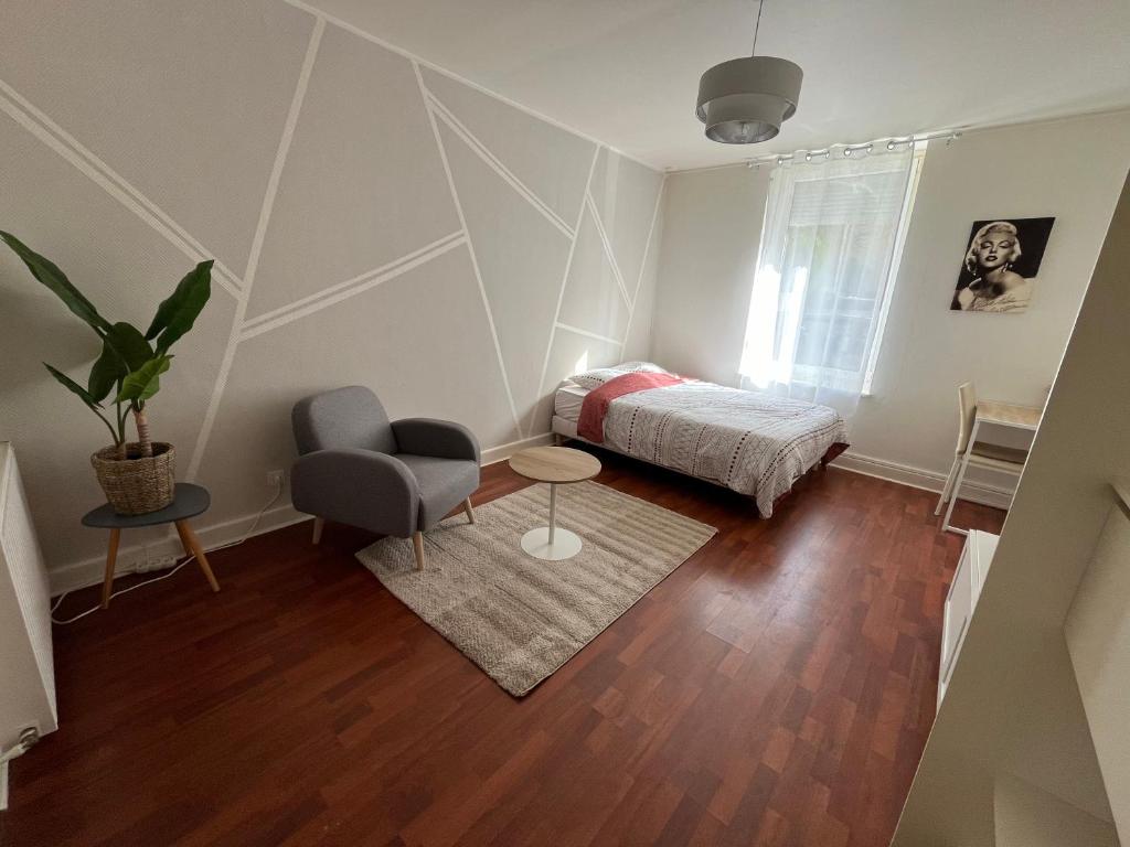 une chambre avec un lit, une table et une chaise dans l'établissement Studio Lux Cattenom Thionville, à Algrange
