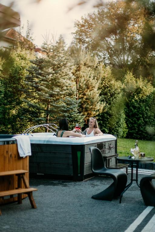 two women in a hot tub in a yard at APARTAMENTY VILLA PIGMALION - sauna, jacuzzi, parking, ogród in Kudowa-Zdrój