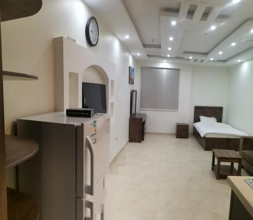 a hotel room with a bed and a tv and a room at شقق مفروشه قارا in Qārā
