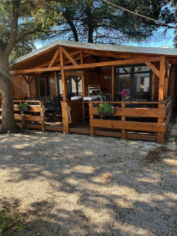 a log cabin with a porch and a fence at Chatka Daisy A,B in Pakoštane