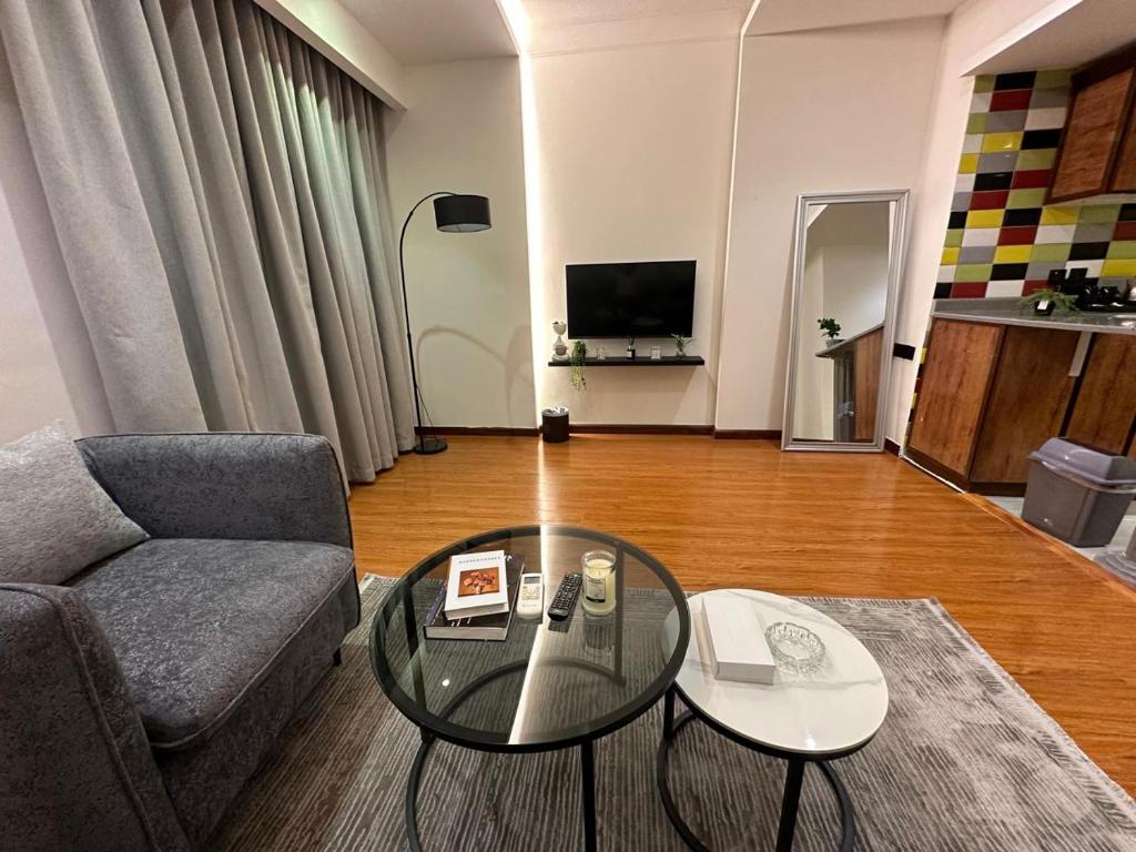 a living room with a couch and a glass table at Afaq Retaj Serviced Apartments in Riyadh