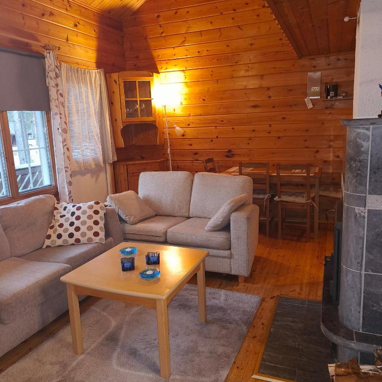 a living room with two couches and a coffee table at SuLevi Apartment in Levi