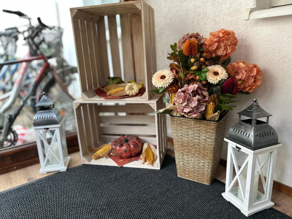 a table with two lights and a basket of flowers at Pension Rosenhof am Bahnhof in Forst